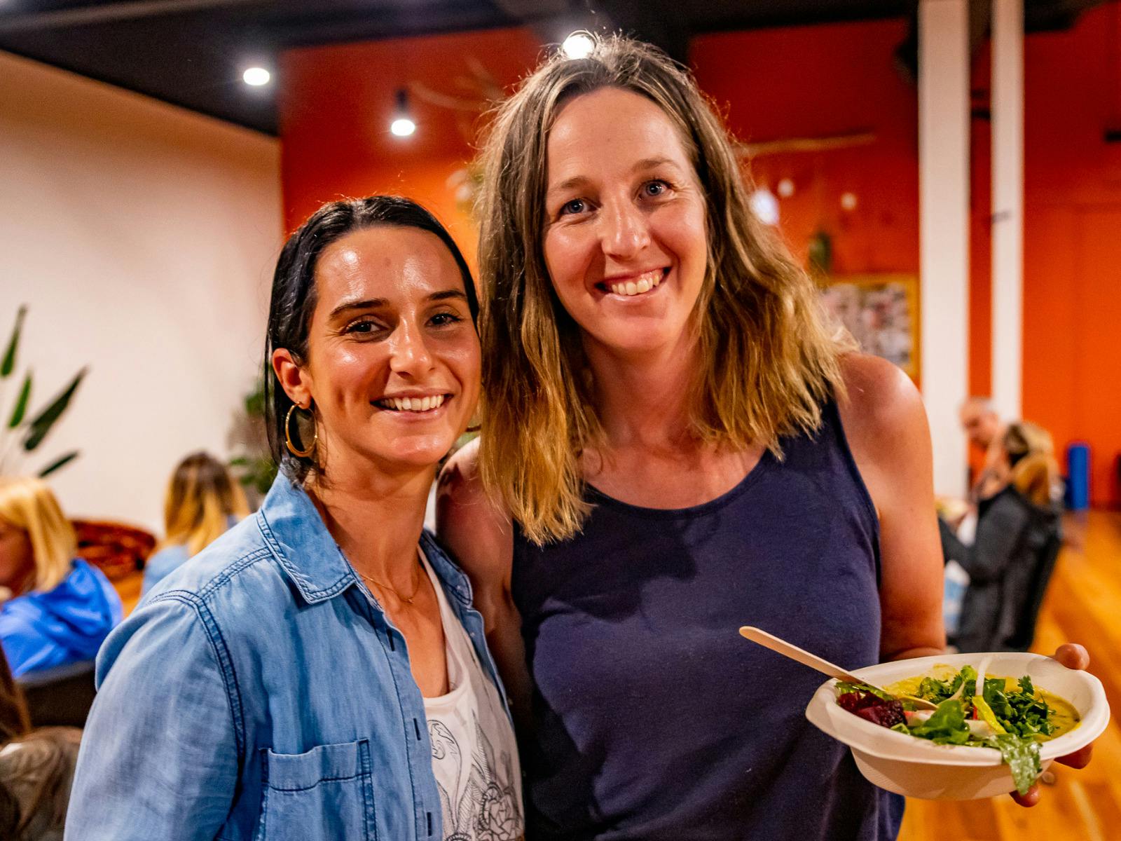 Two women smiling while eating