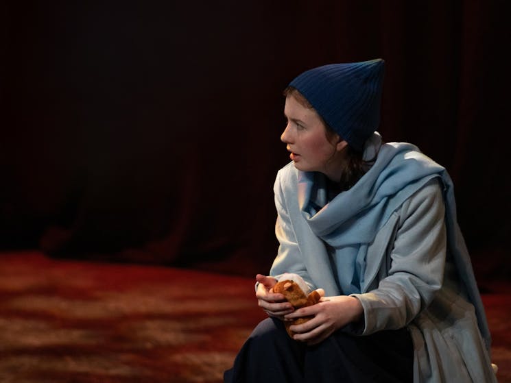 Young actress on stage wearing a beanie and a scarf