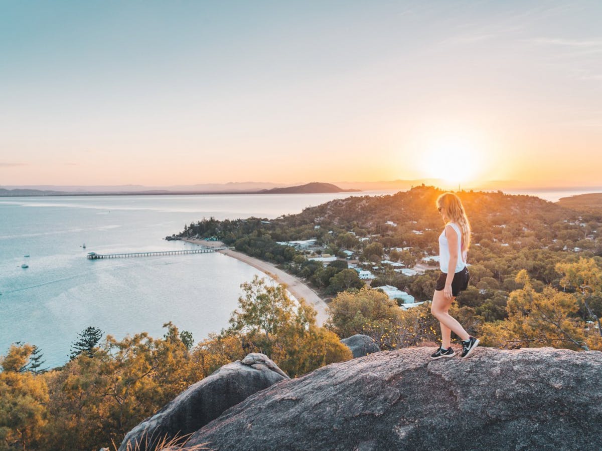 A person standing on a rock looking out over a body of water