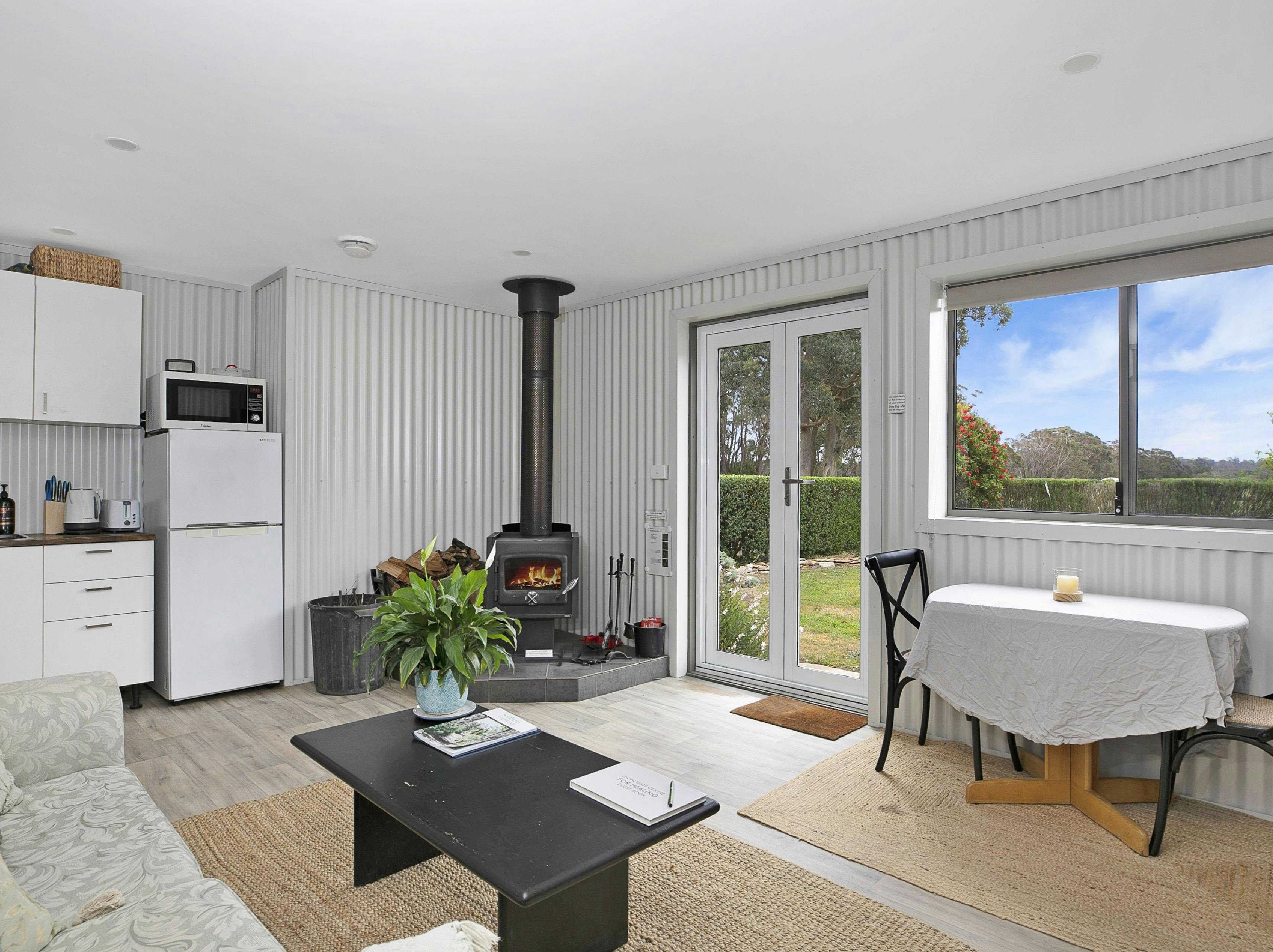 Living room at The Stables with woodfire and access into garden