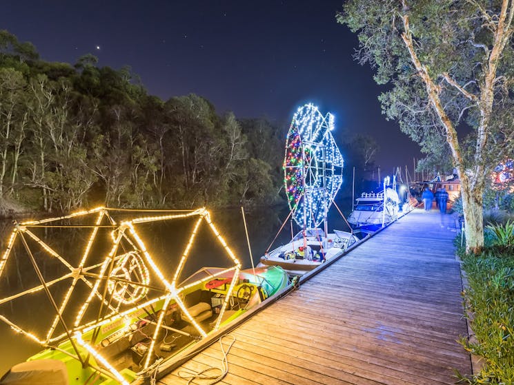 Boat decorated with fairy lights photographed from foreshore