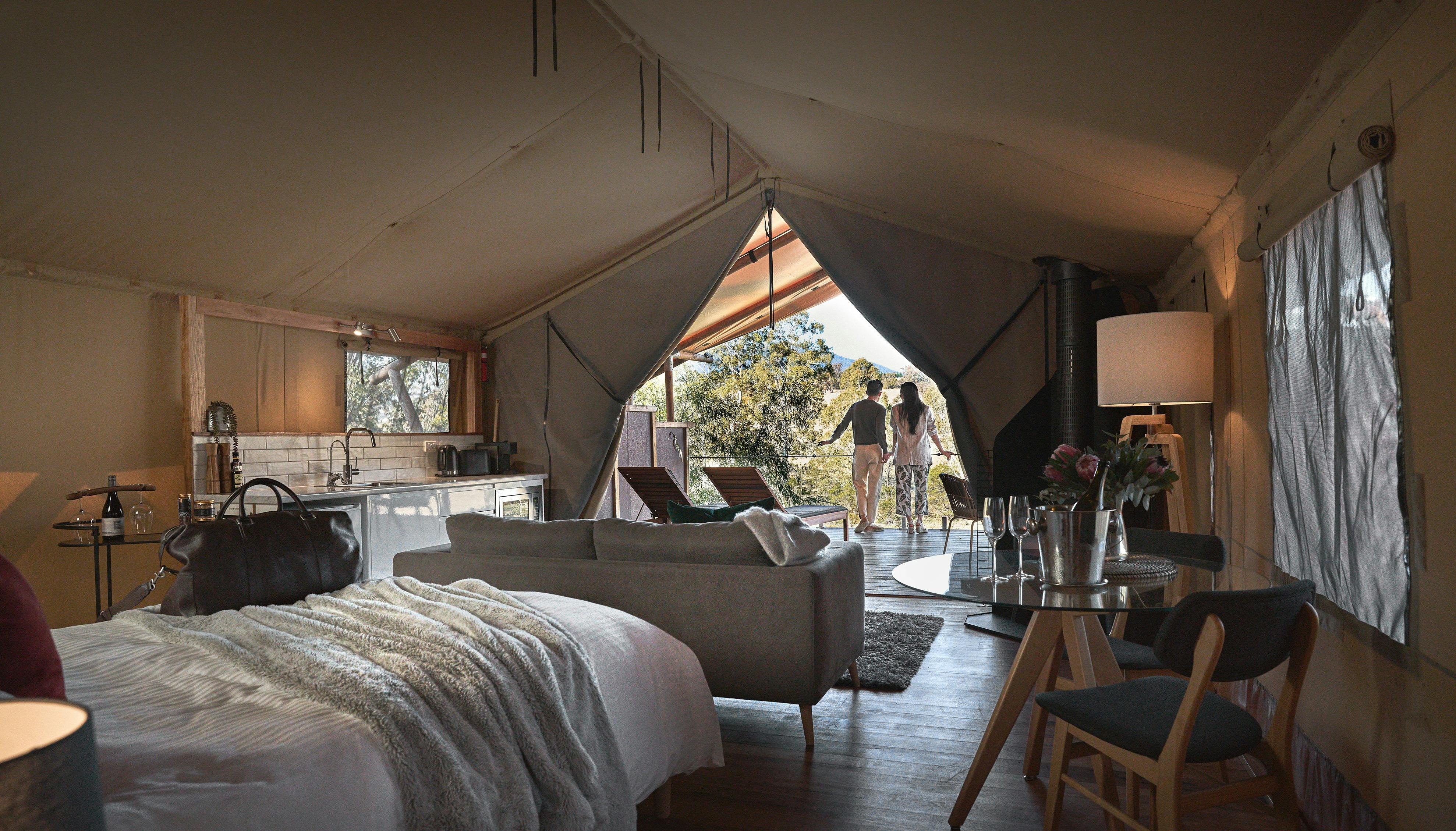 ベッドからラウンジ越しにベランダまで眺める豪華なサファリテントの内部
