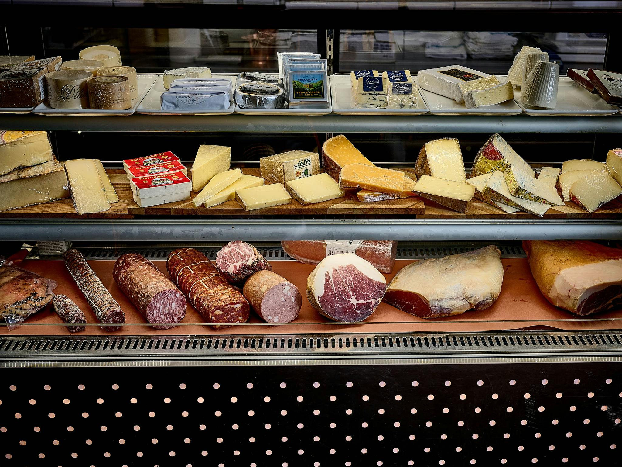Deli display of cheeses and cured meats