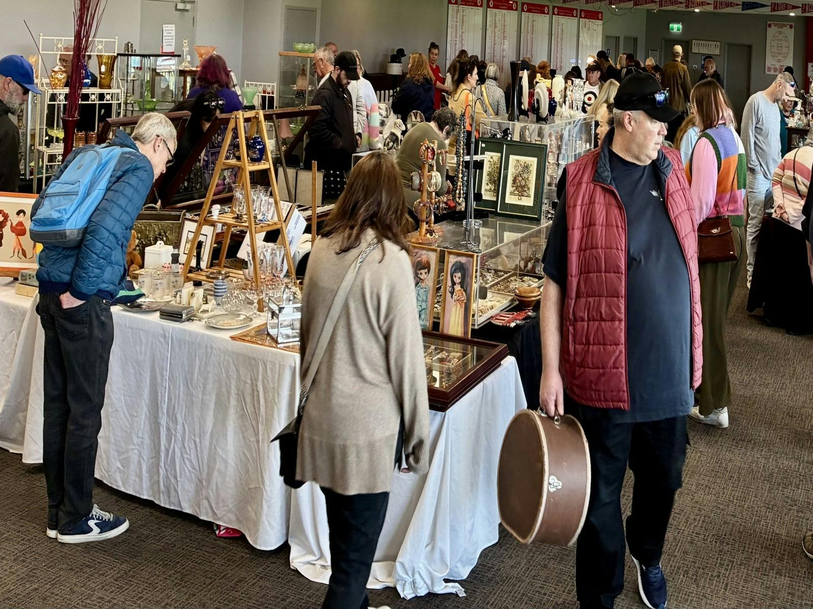 Antique Fair visitors looking at the antiques for sale.