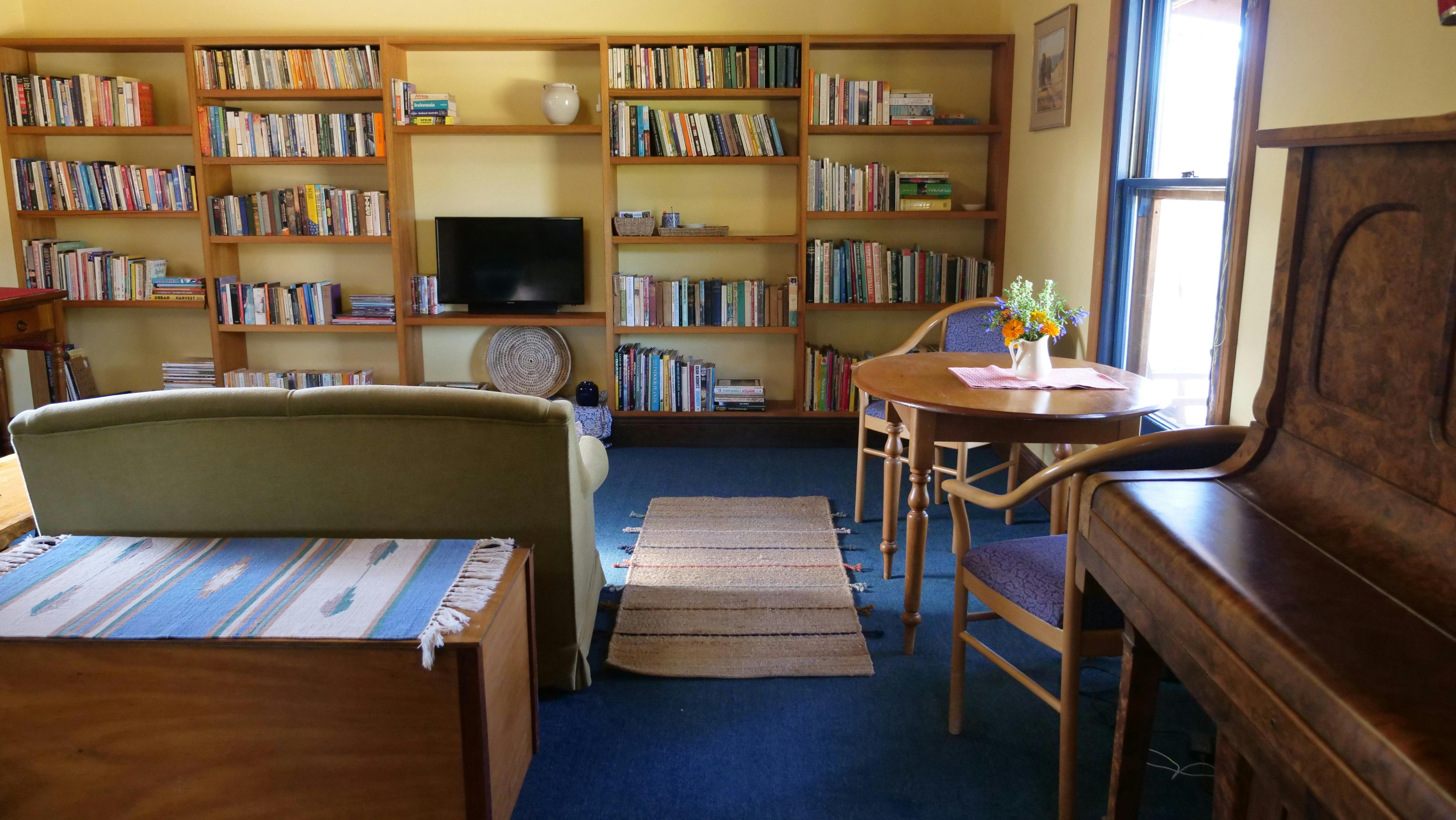 Living area showing extensive bookshelf and abundant books