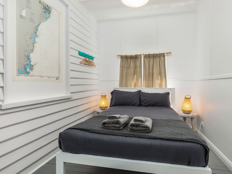 Bedroom with window behind bedhead, gray and white decor