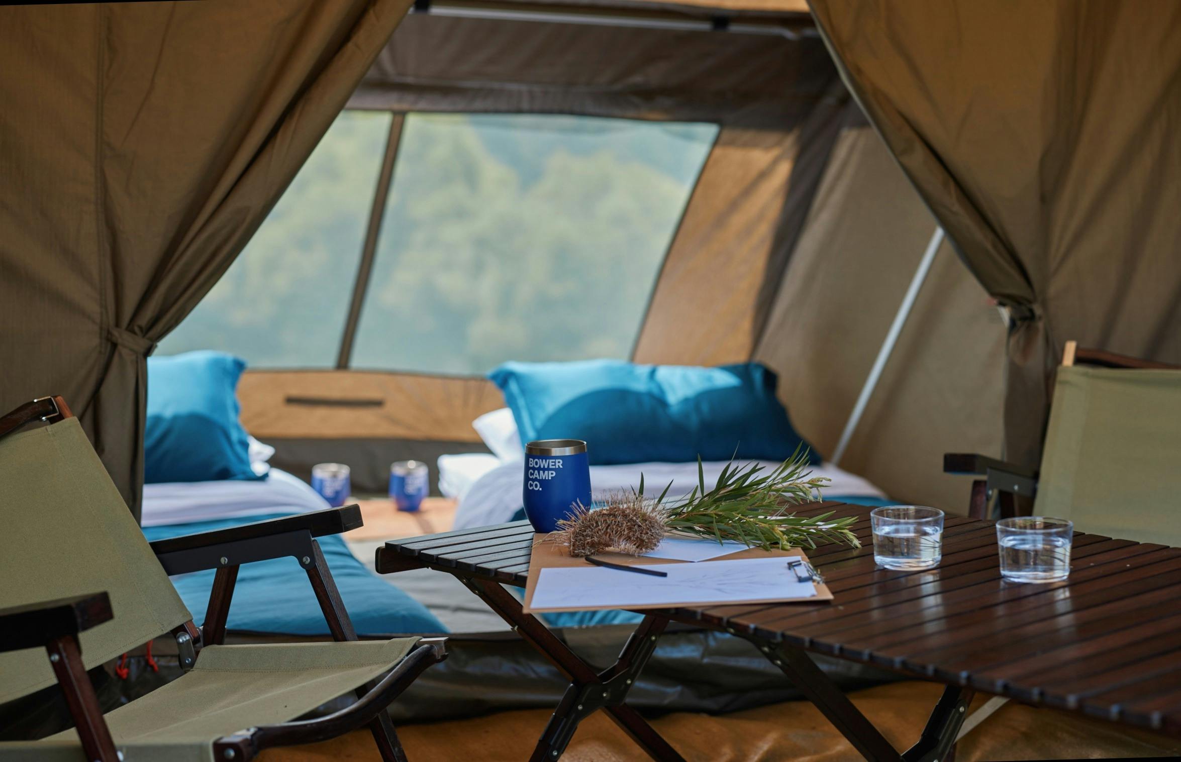 帐篷内部配有两张铺好的床、桌子和椅子。