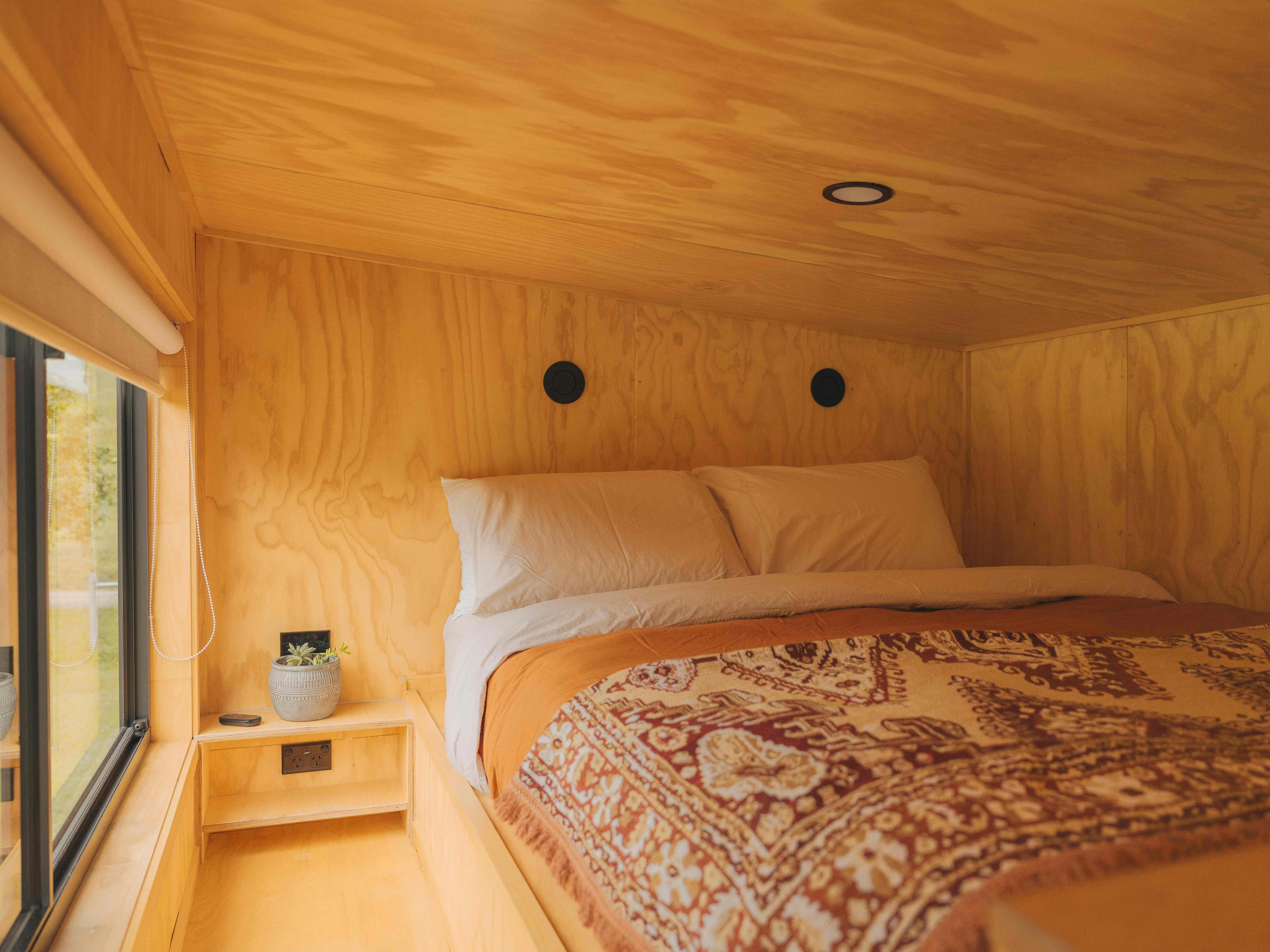 Mullumbimby의 럭셔리한 소형 주택에 있는 아늑한 로프트 침실에는 자연을 바라보는 퀸 사이즈 침대가 있습니다.