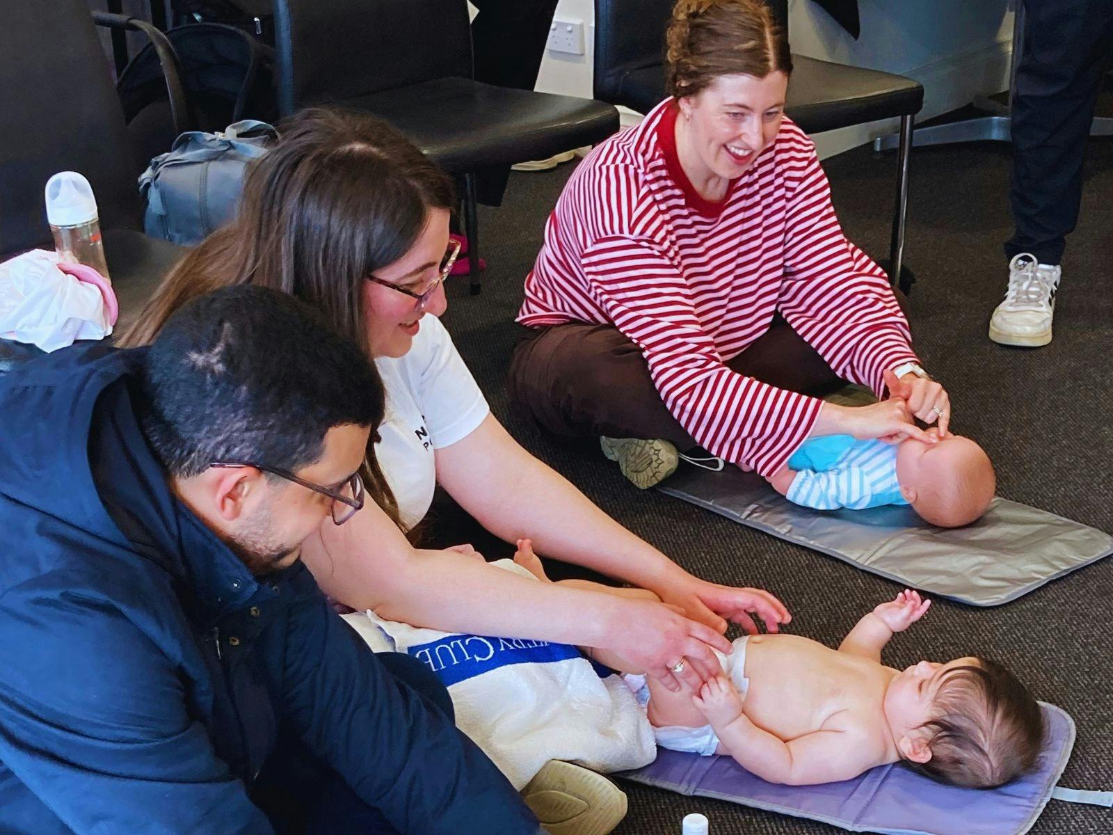 Parents practising baby massage with their babies during an Infant Massage Information Service sessi