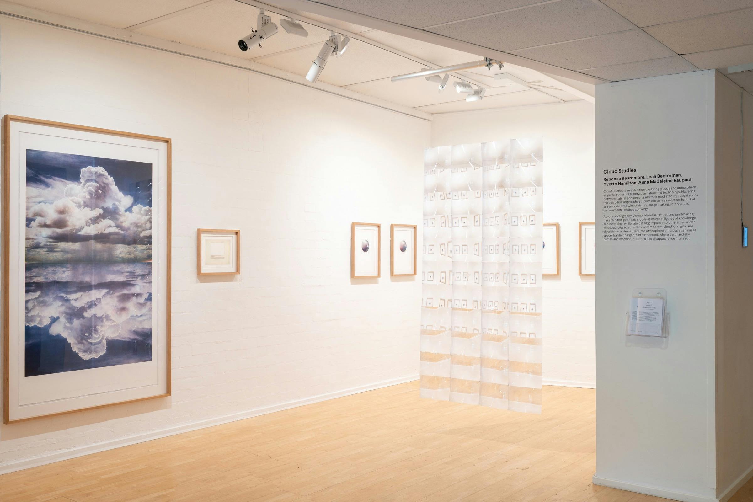 Cloud Studies gallery: large framed cloud photo, small framed prints, hanging translucent panel.