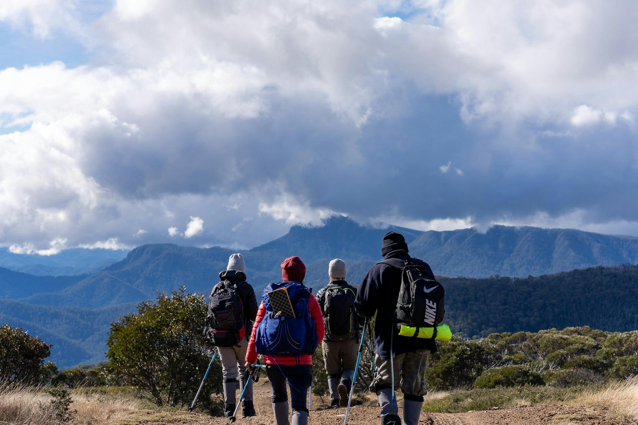 A group of hikers on top of Mt Stirling with views of surrounding peaks