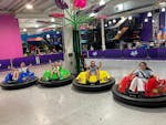 4 teenagers give the thumbs up in brightly coloured bumper cars