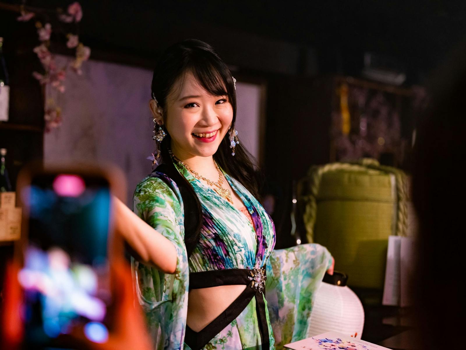 Japanese magician in green kimono smiles at the camera