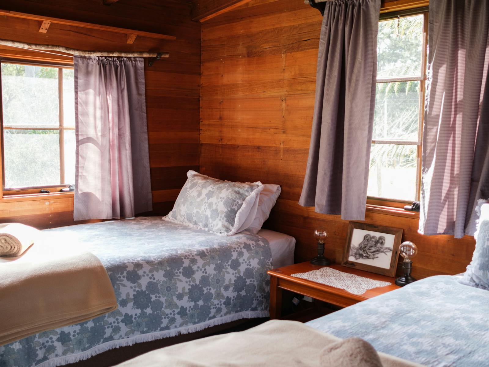 Two king single beds in a light filled room made from blackwood