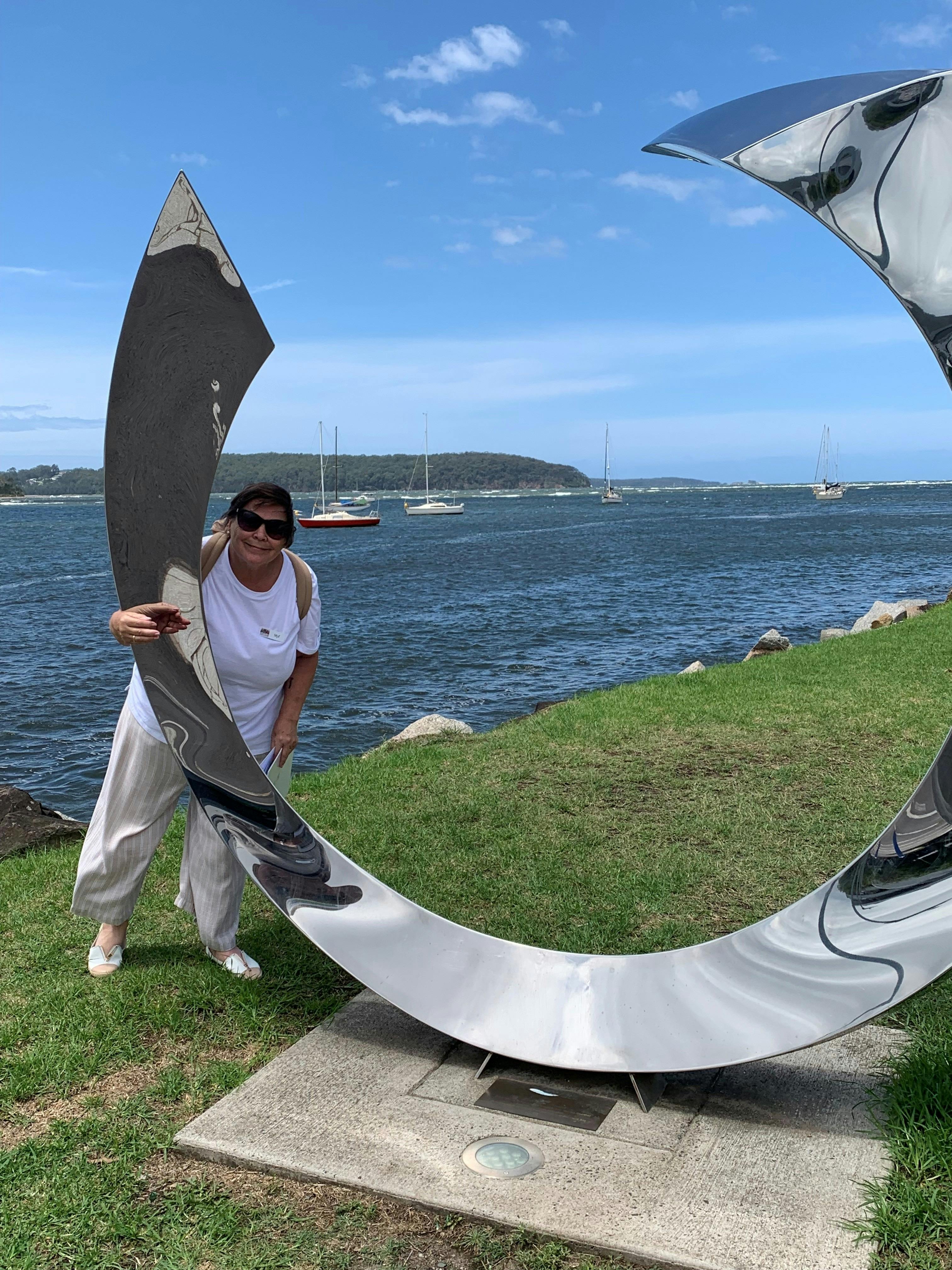 Woman next to stainless steel sculpture at Batemans Bay