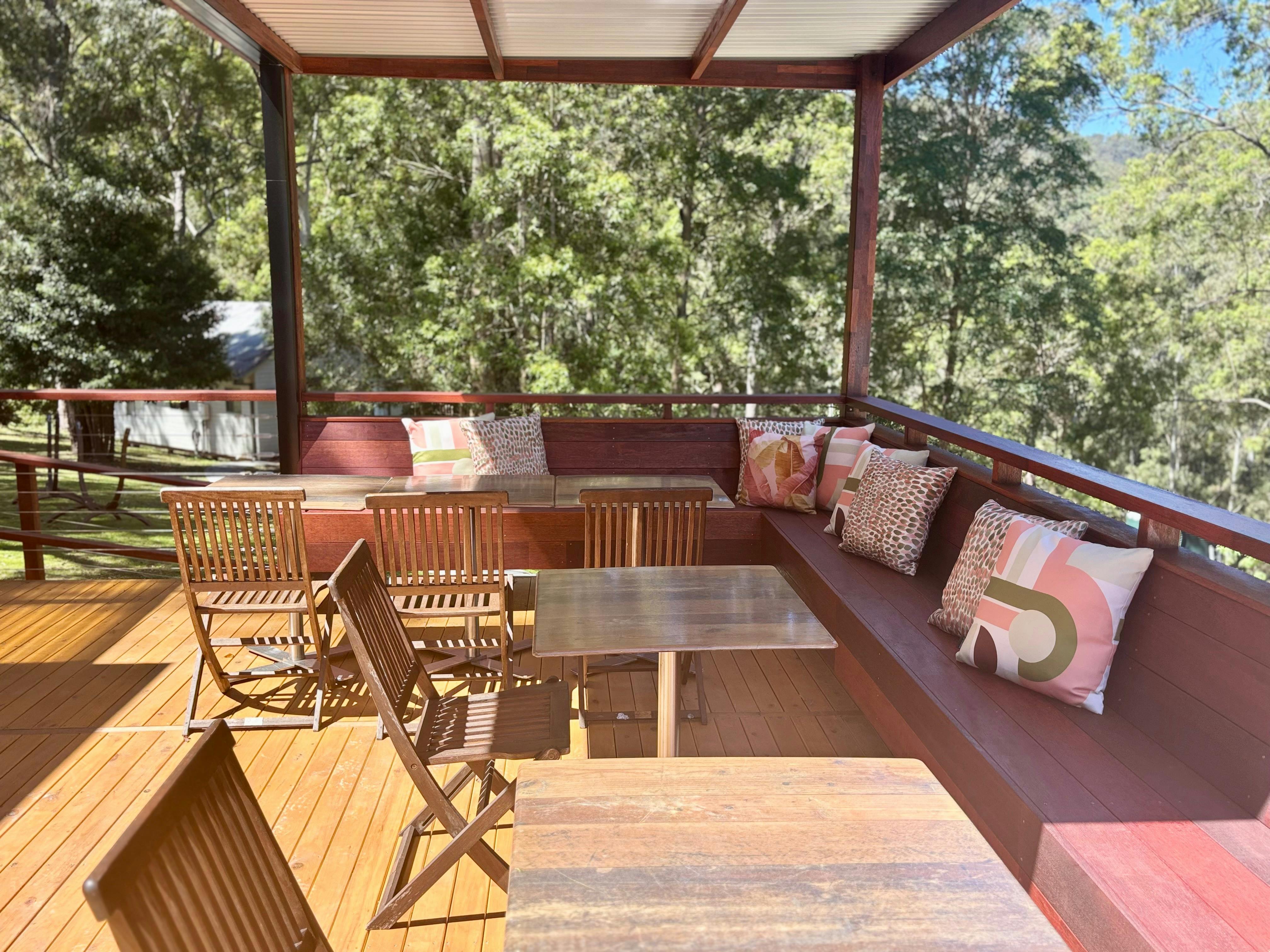 Table and chairs under a cabana on a big beautiful wooden deck