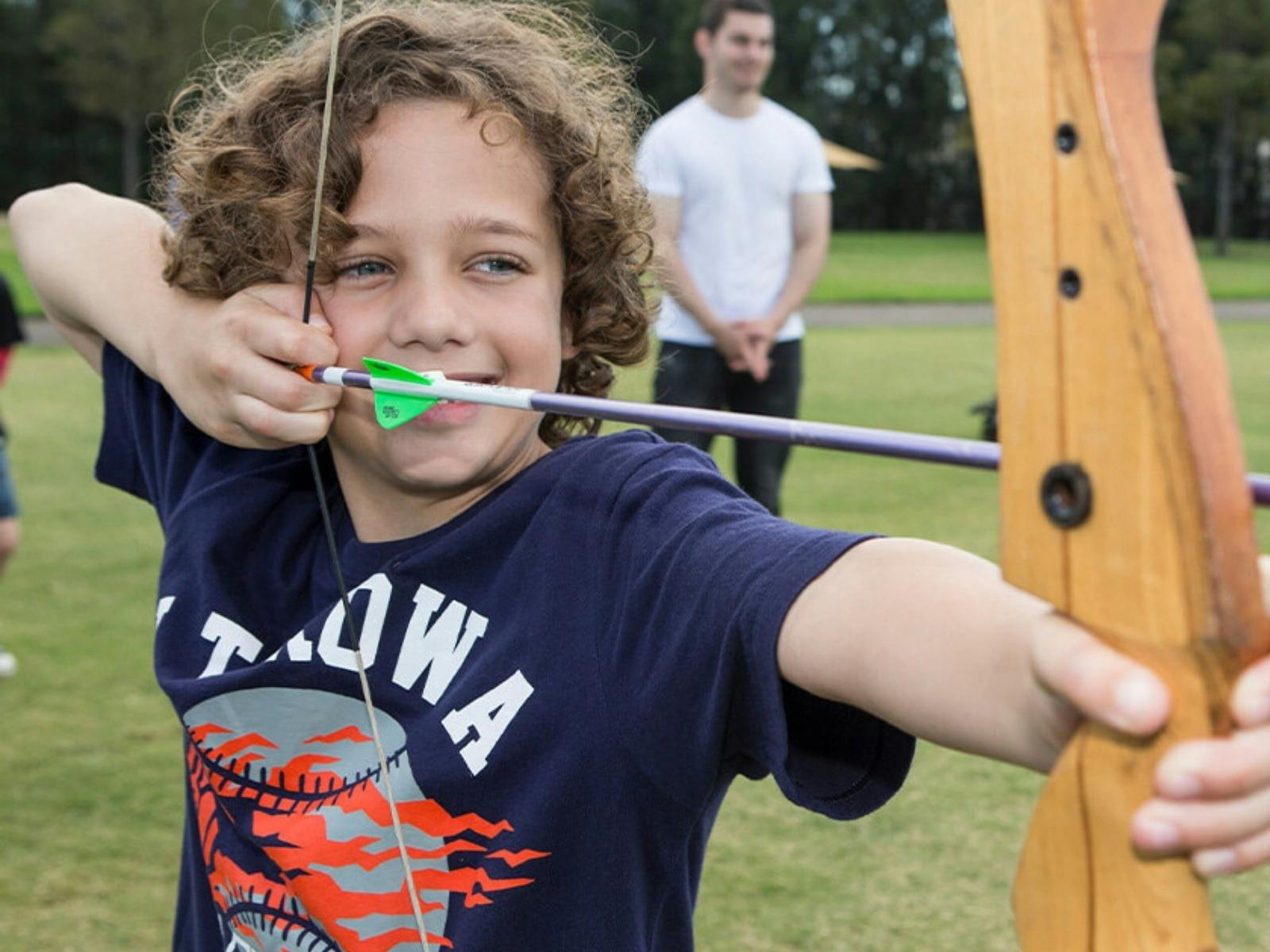 Kid lining up the perfect shot at the bullseye