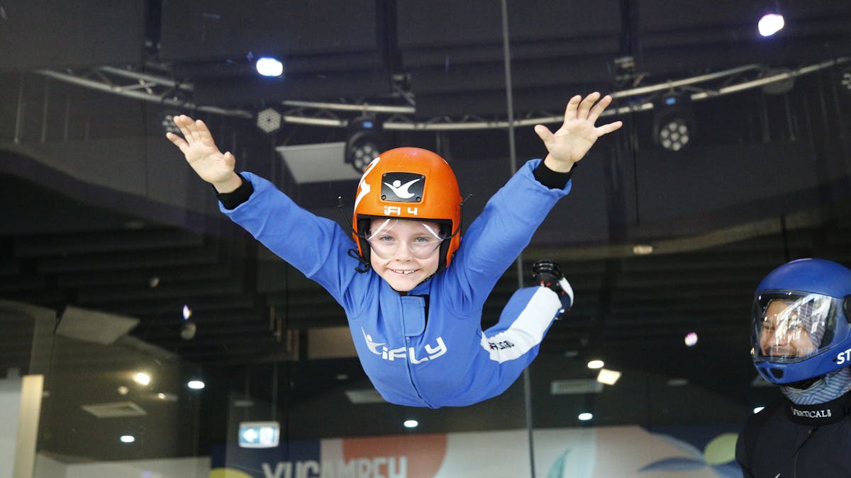 Small boy flies unassited in a blue suit