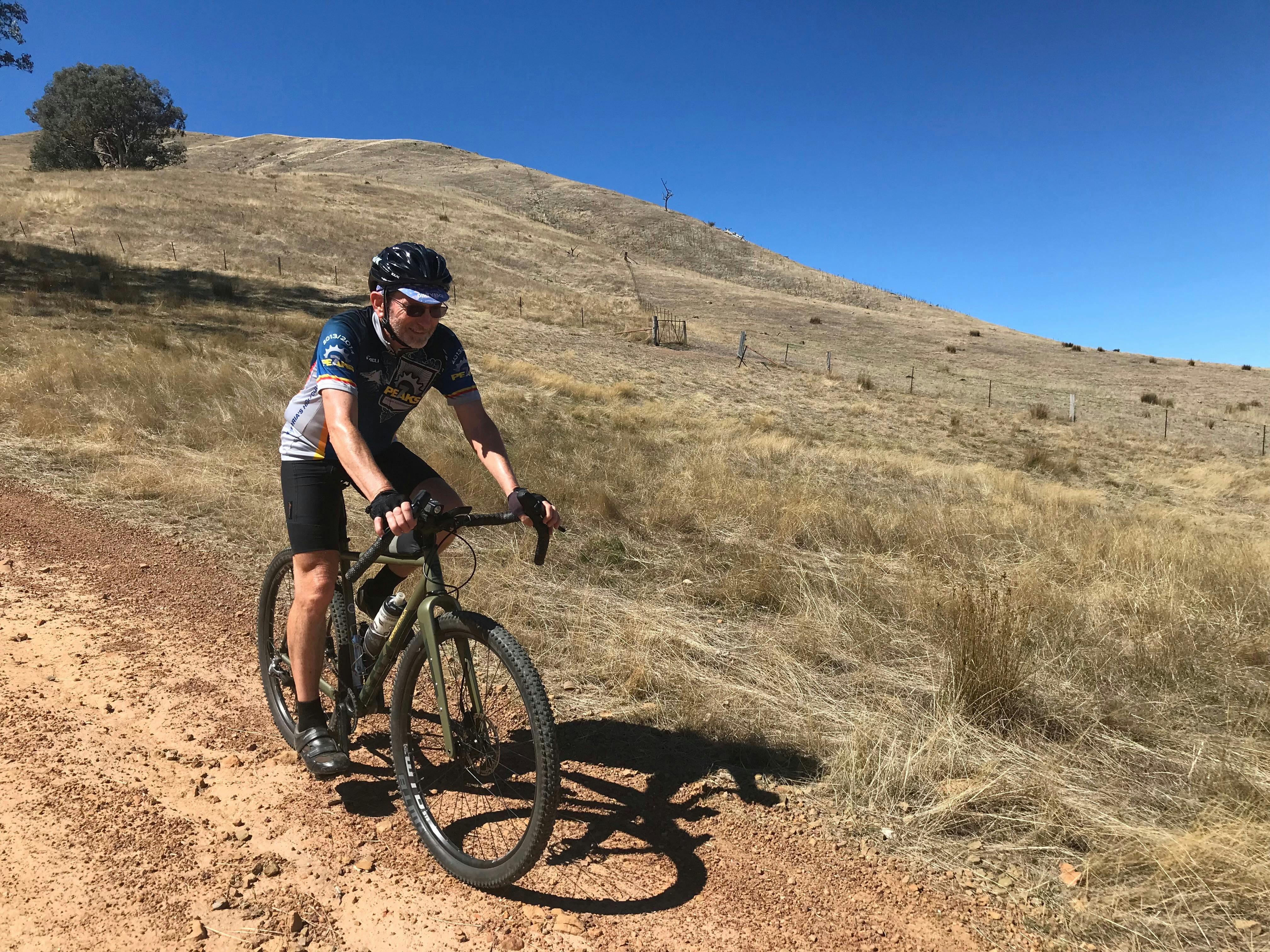 Rider descending on track in hill country on a blue sky day