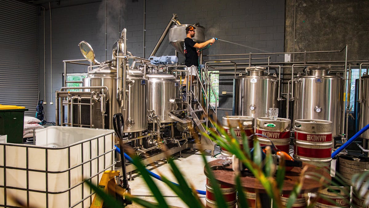 Brewer busy making ice cold fresh craft beer with the stainless brew kit. Brewer busy making ice cold fresh craft beer with the stainless brew kit.