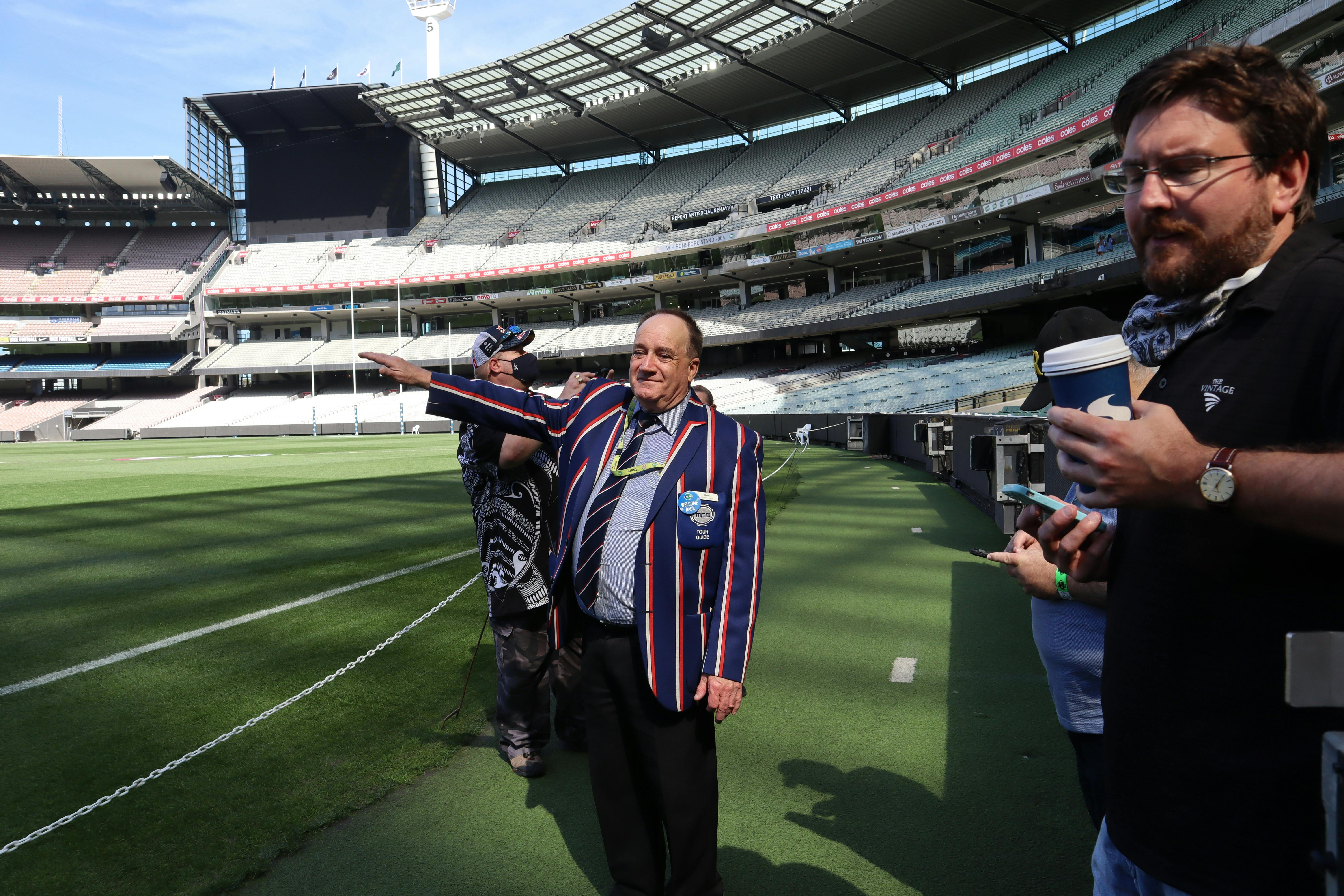 Tour host and guests standing on the ground at the MCG