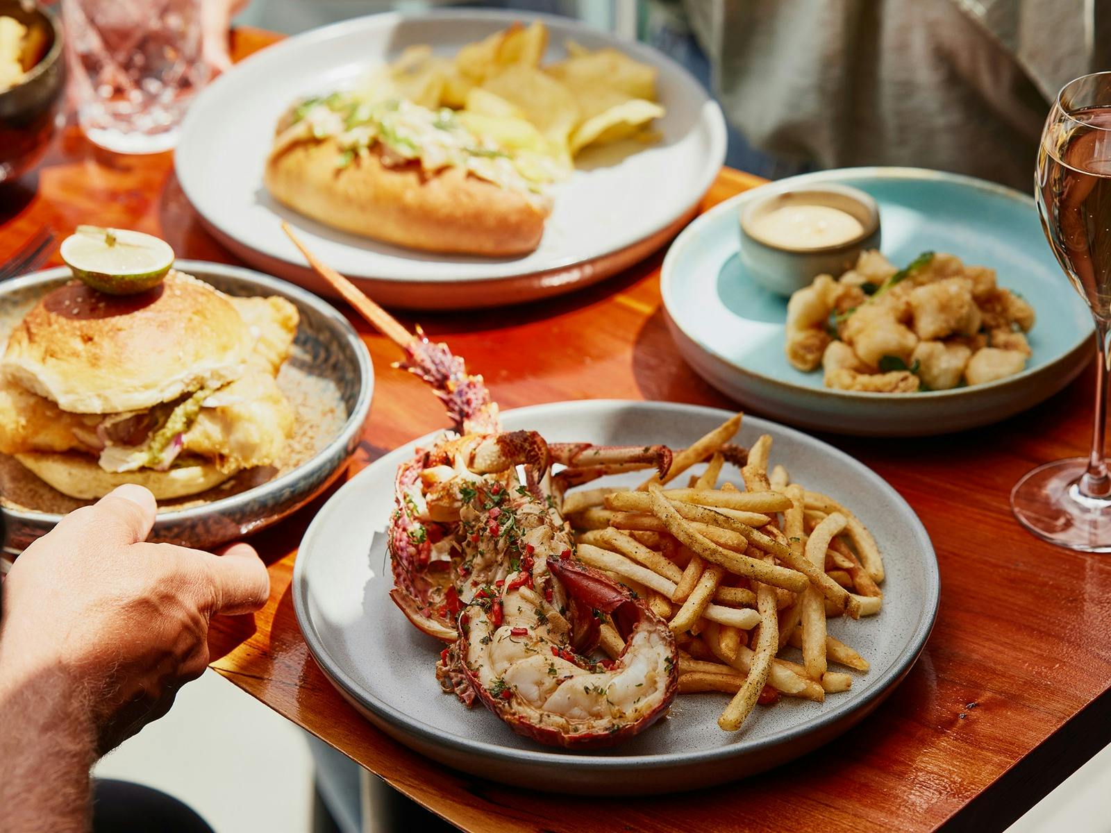 A table with different food dishes, all featuring Tasmanian Southern Rock Lobster.