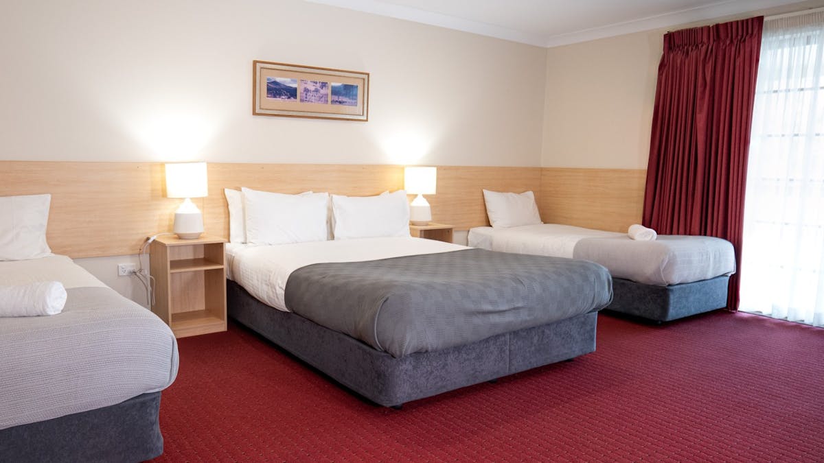 a clean comfortable room with 3 beds at the Ballandean pub
