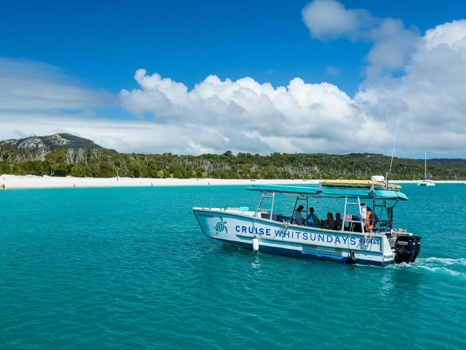 A group of people being taken to the beach on a small boat