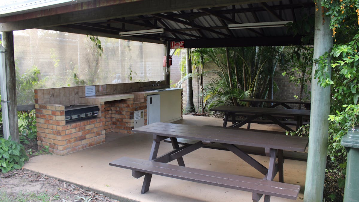 Undercover camp kitchen, picnic tables, BBQ, bar fridge and sink.