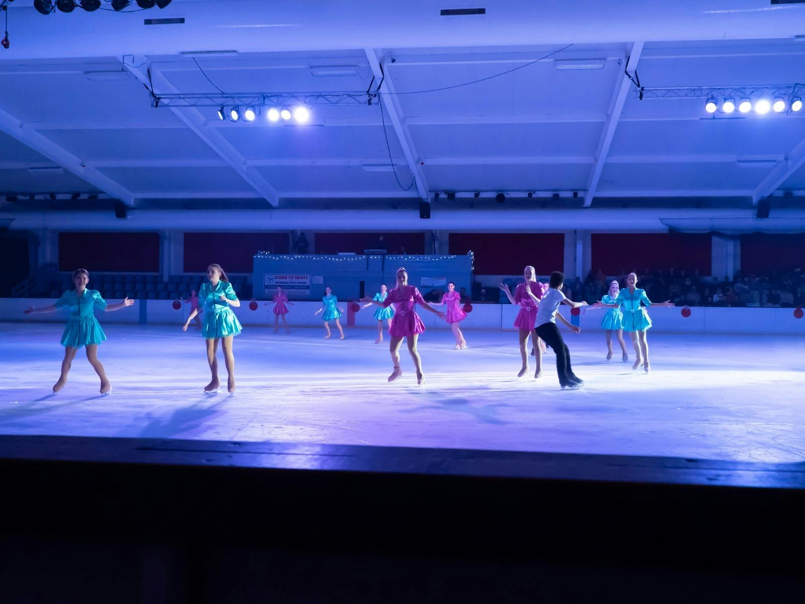 Figure skaters in pink and green costumes
