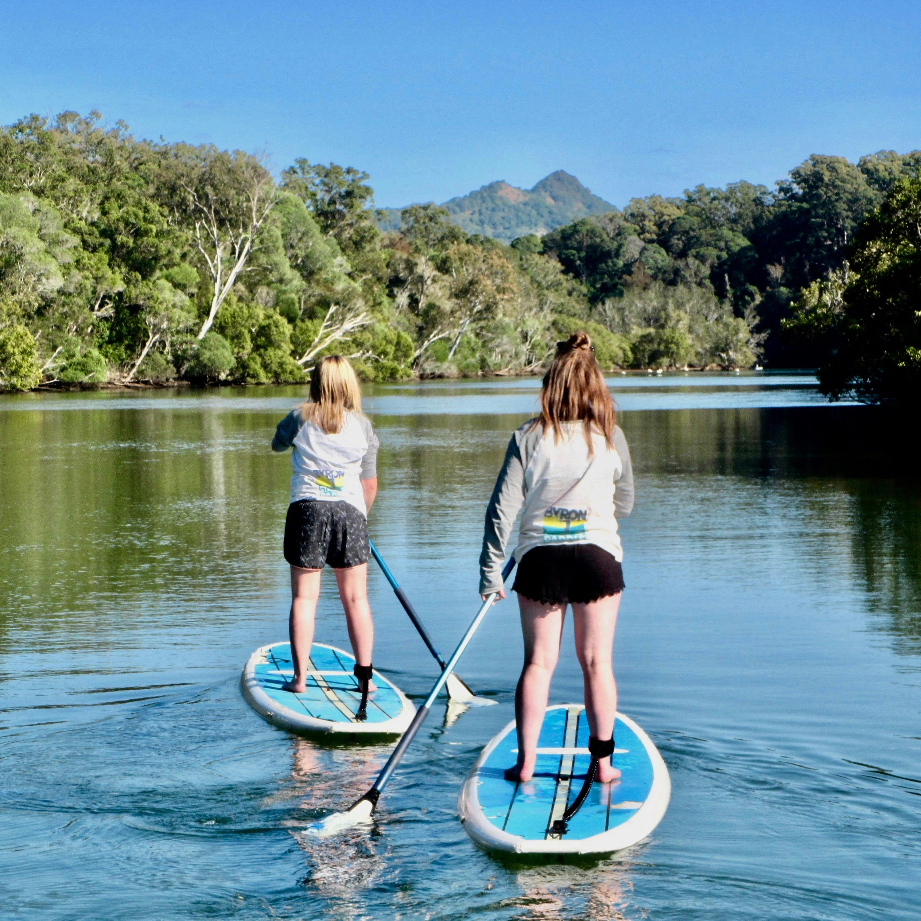 Friends paddling on the Byron Stand Up Paddle Nature Tour with the mountains in the distance