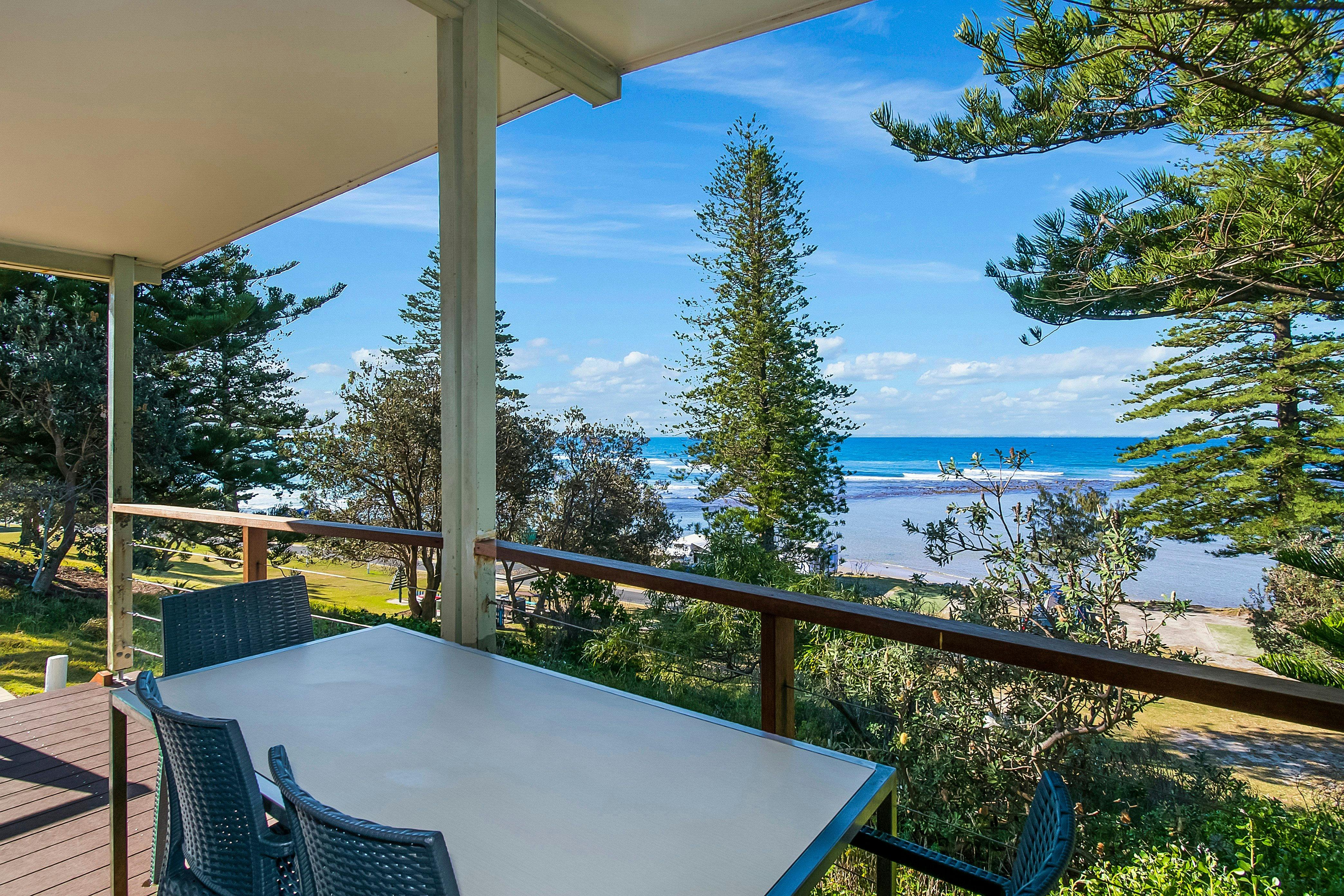 Esstisch im Freien auf einer Terrasse mit Panoramablick auf den Ozean