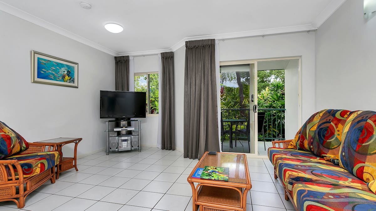 Open plan living and ding areas with flat screen TV and picture windows.