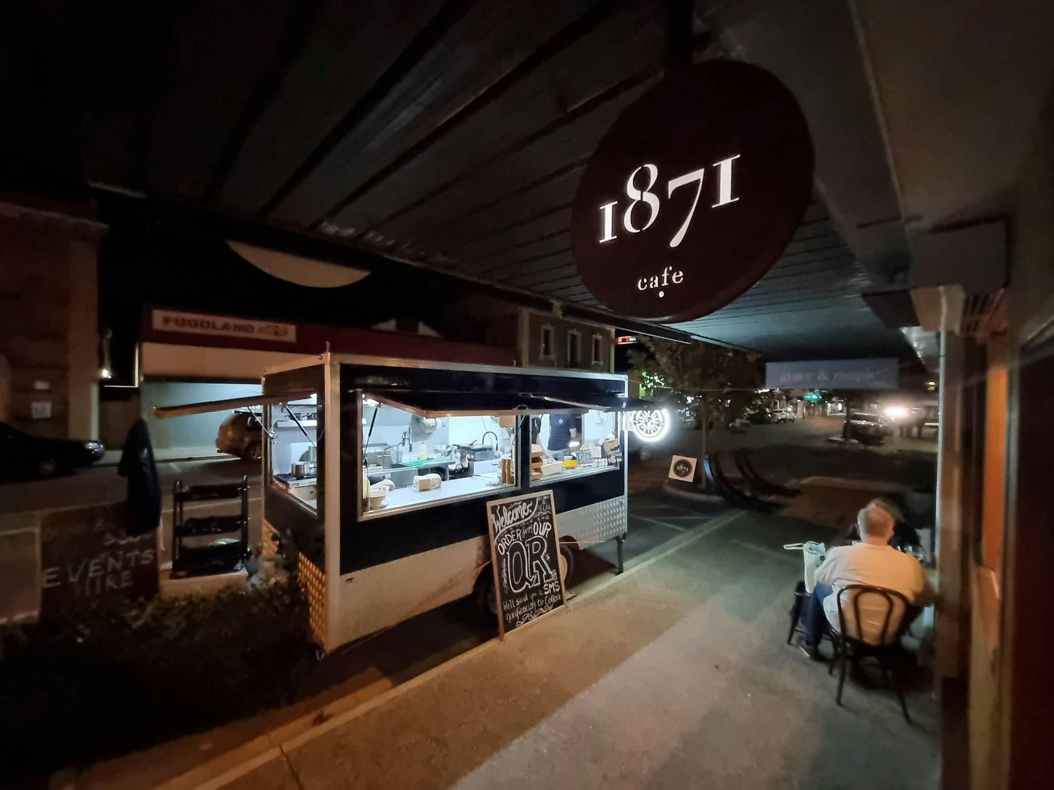 Food truck 'Funk Sol Brother' parked curbside with the Cafe 1871 sign at night time.
