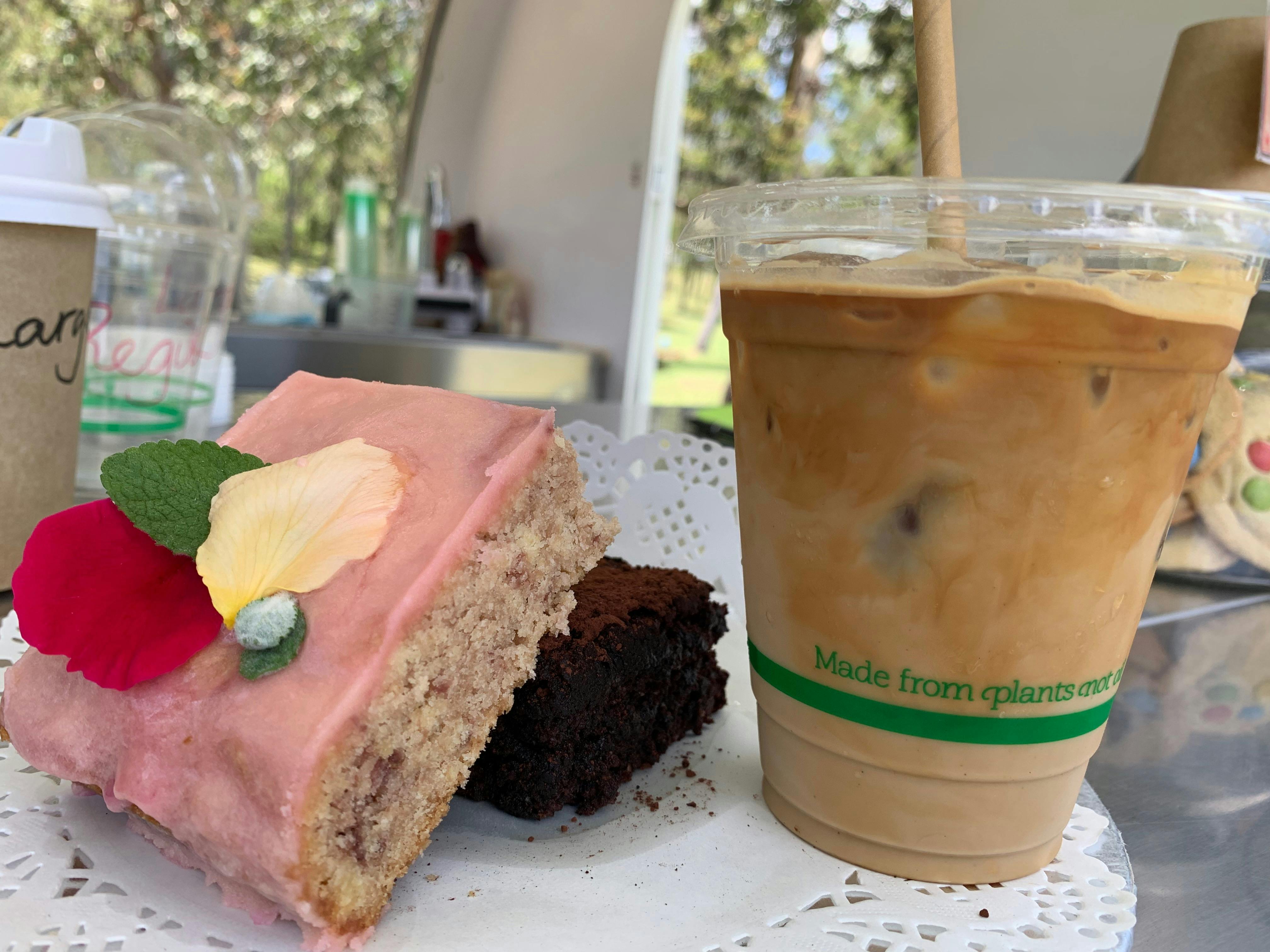 Home baked strawberry slice with edible flowers and mint, chocolate slice, iced latte