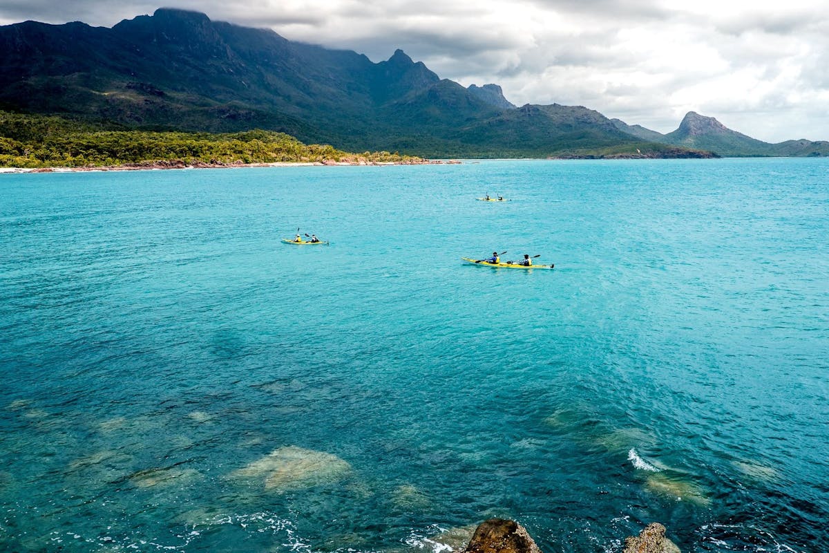 Mt Bowen & Nina Peak tower in the background as we paddle across a turquoise bay on Hinchinbrook