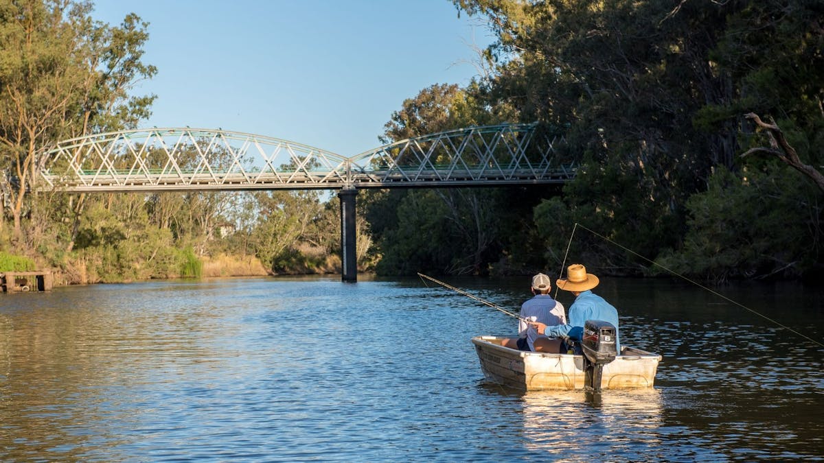 Fishing from a tinny on the Mcintryre River with Historic Border Bridge in the background
