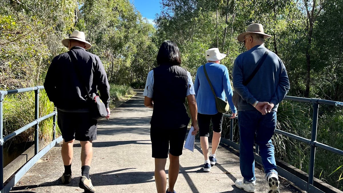 A guide walking and talking with visitors along the wetlands walk