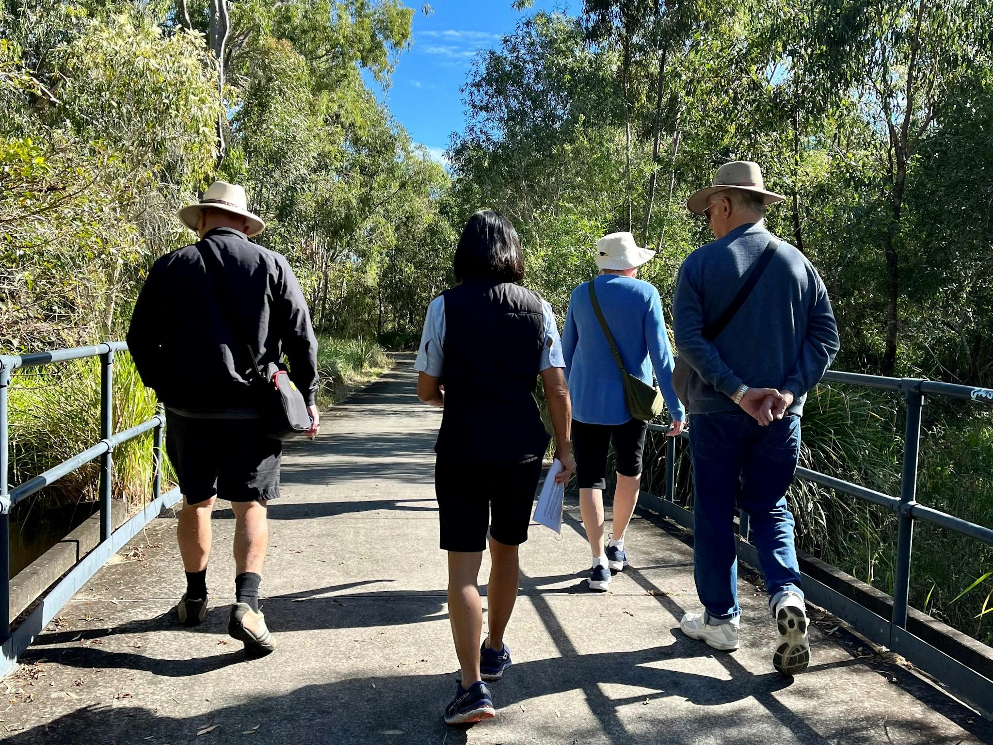 A guide walking and talking with visitors along the wetlands walk A guide walking and talking with visitors along the wetlands walk