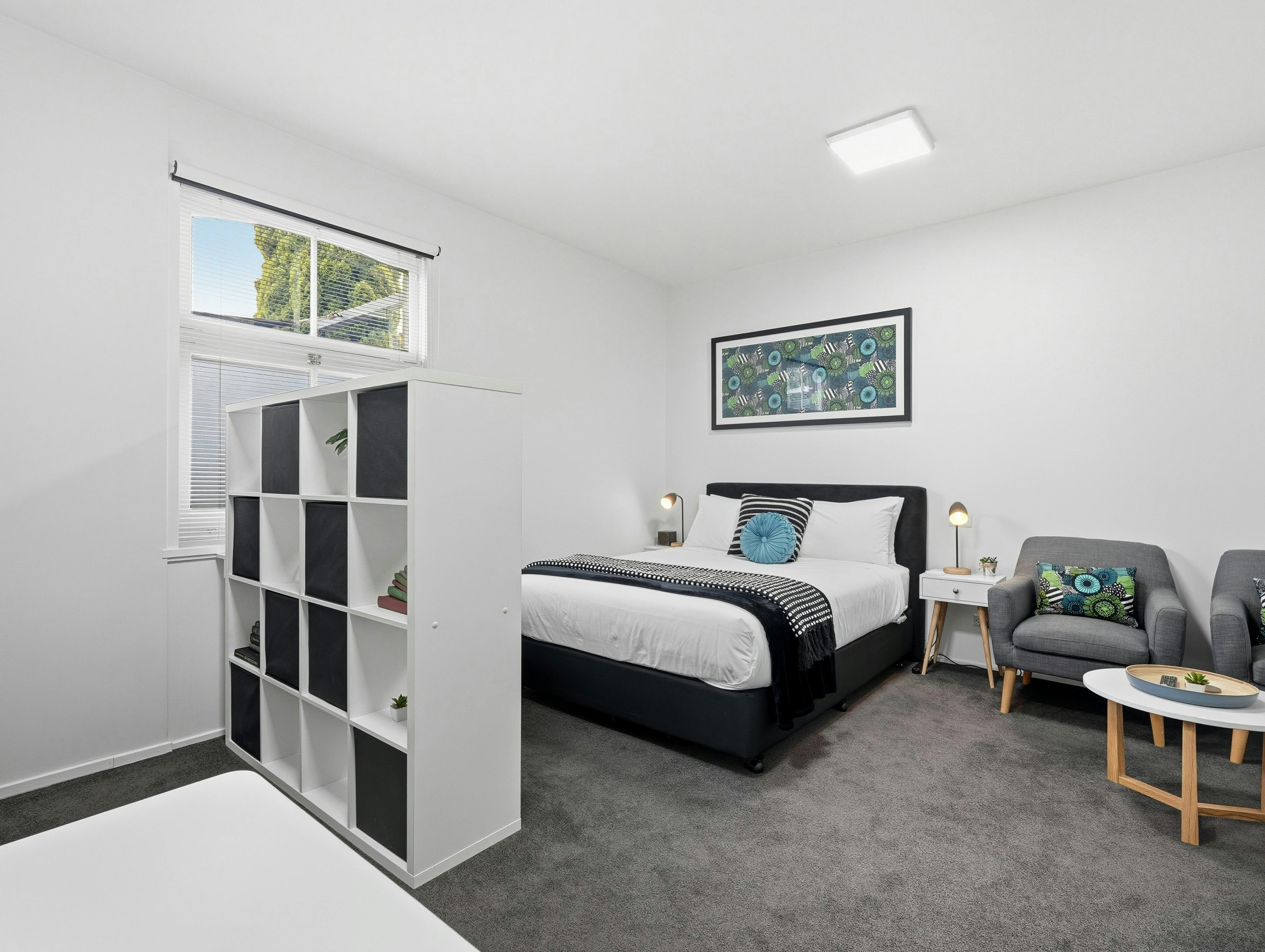 Open-plan studio featuring the queen bed, lounge and dining area
