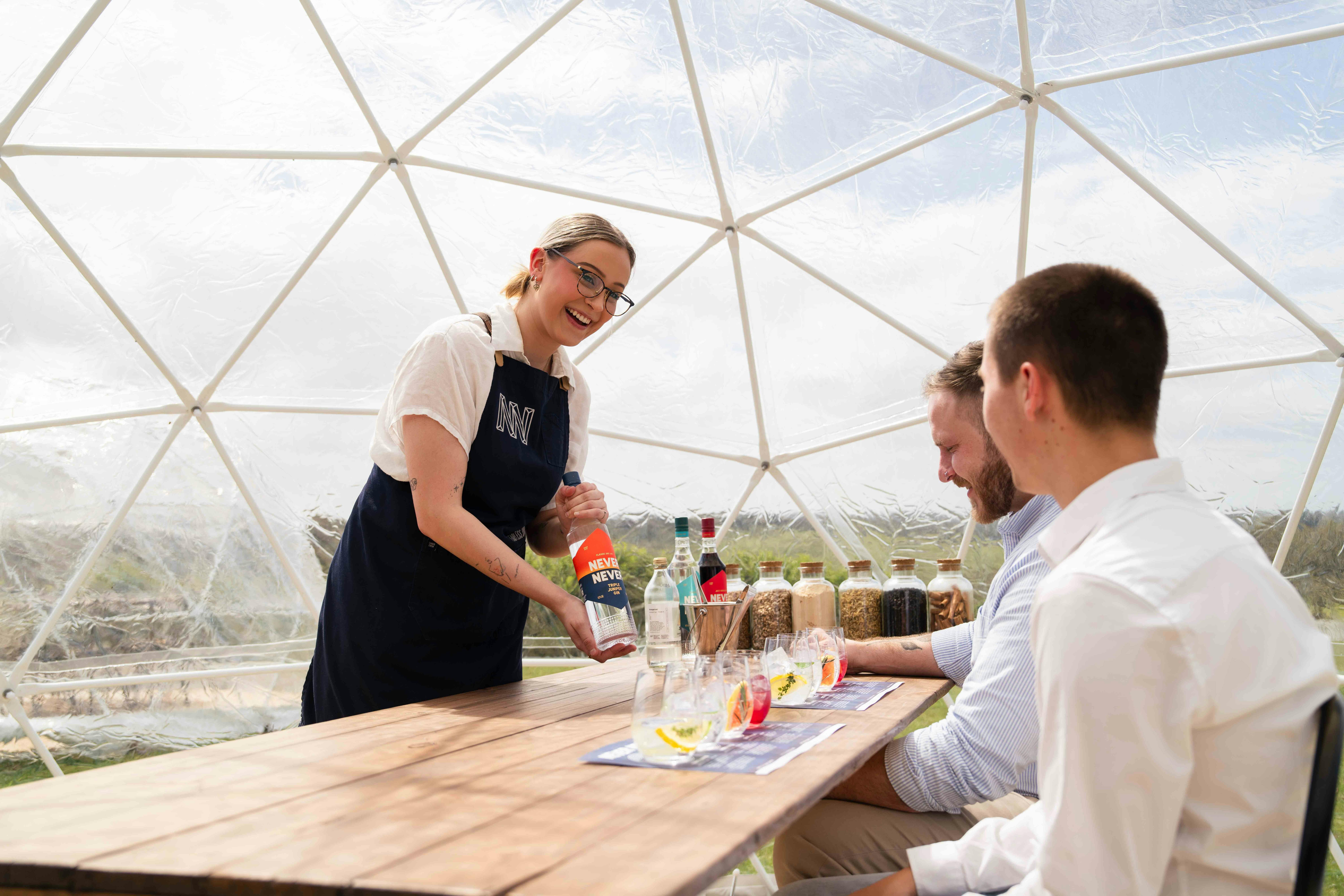gin expert guides guests through tasting with glasses on table