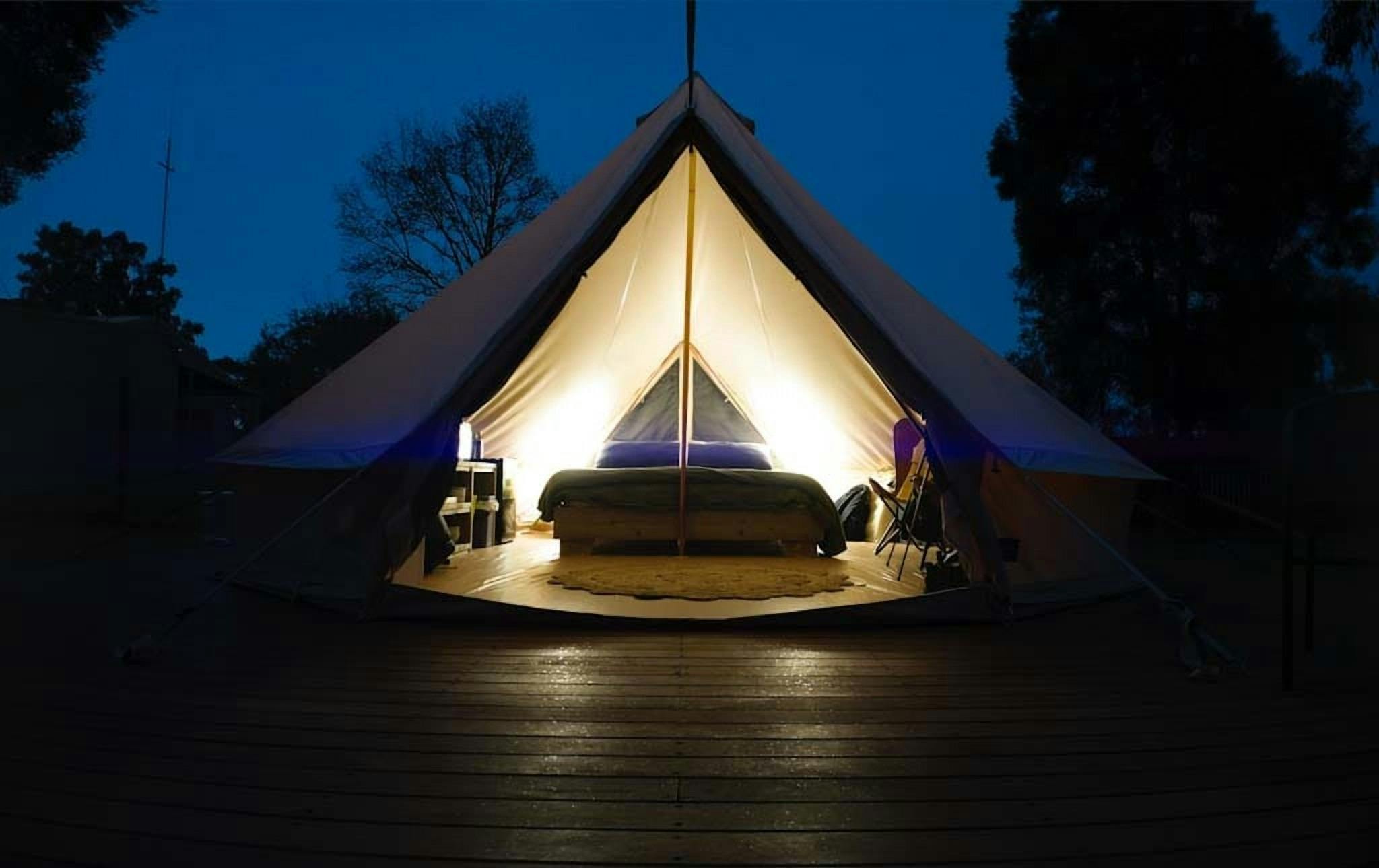Glamping tent lit up at night