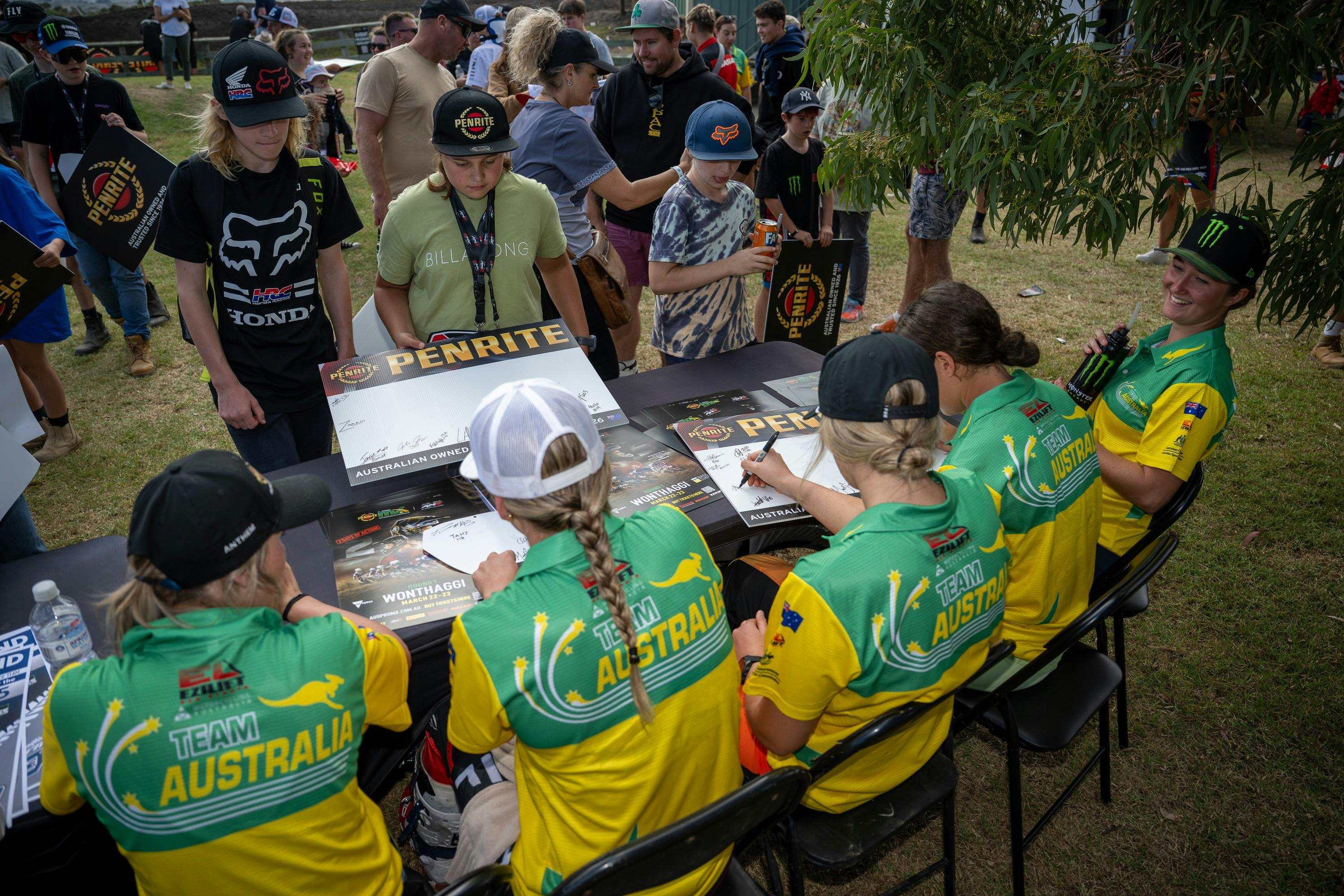 A group of riders sign posters for fans