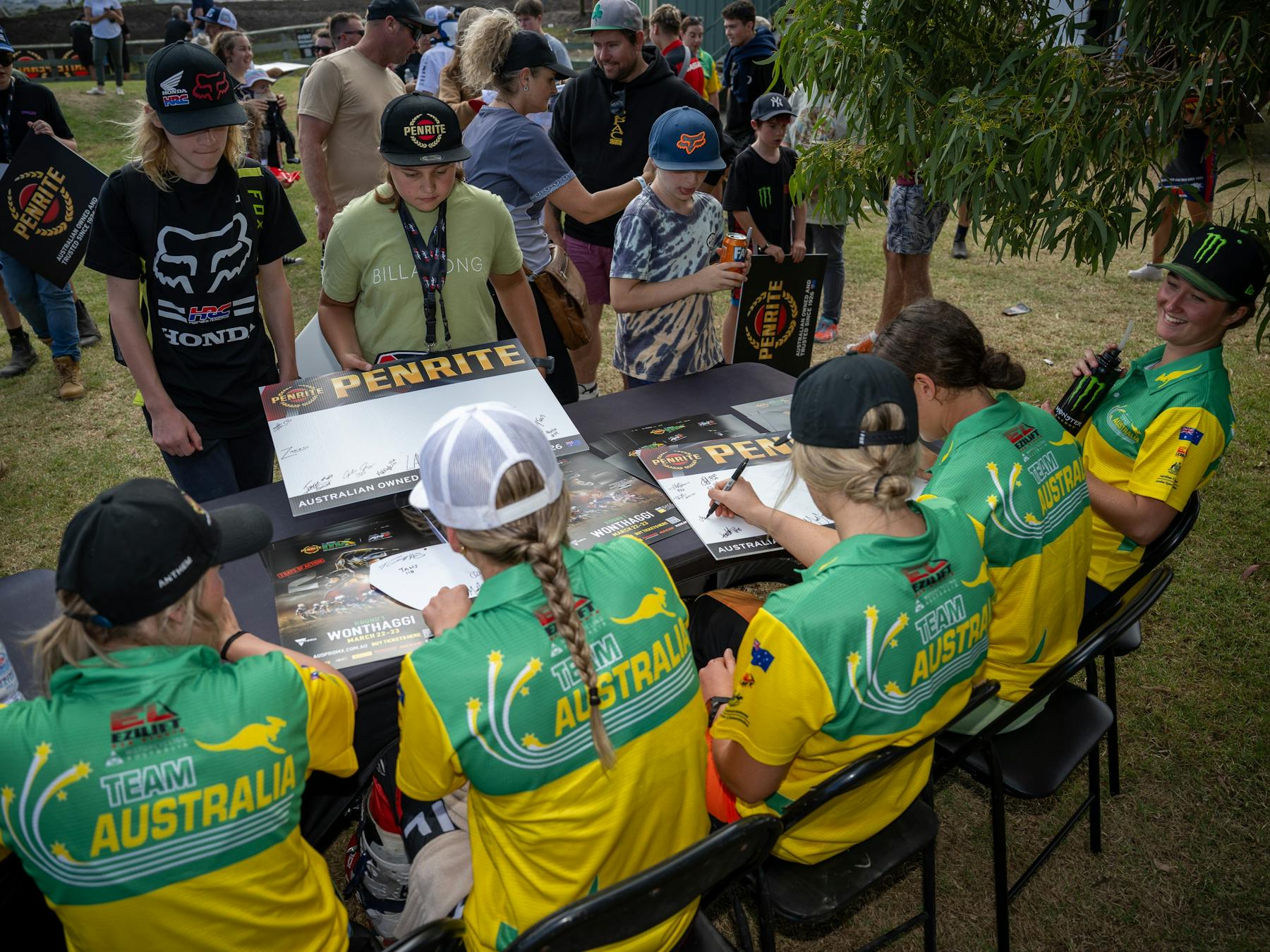 A group of riders sign posters for fans