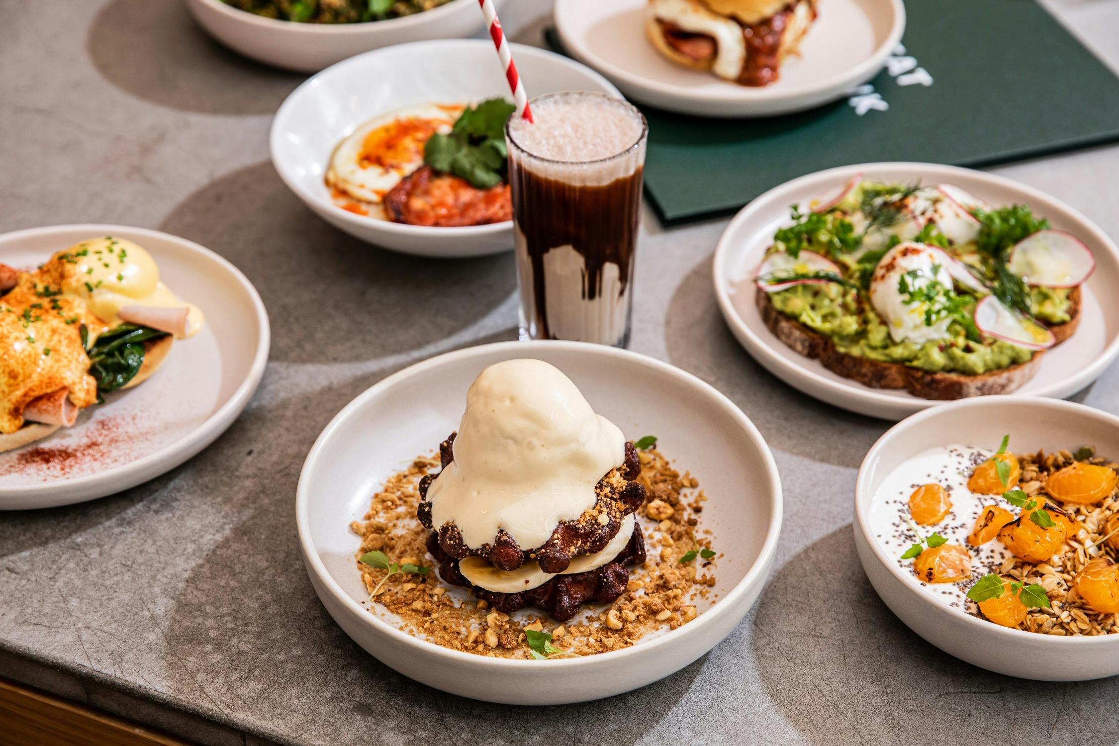 Range of breakfast dishes including waffles, avocado on toast and a milkshake
