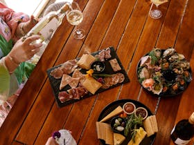 Glass of wine and food platter in a cellar door environment