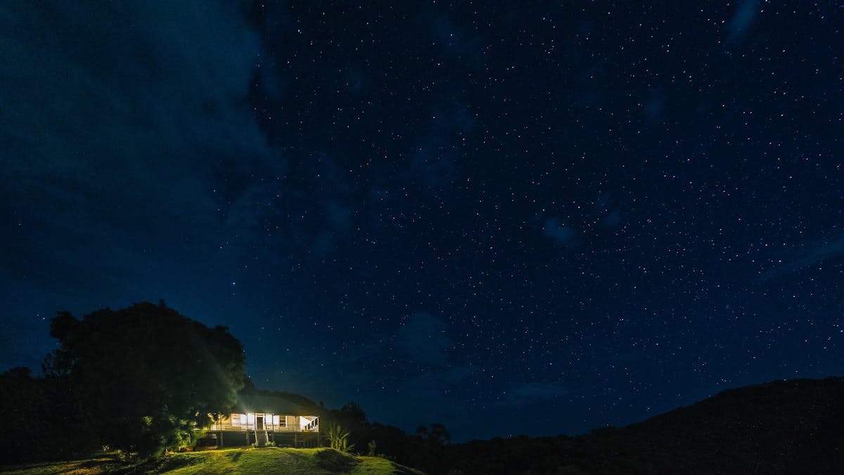 Photo of Myola Farmhouse at night, with spectacular night skies in the background