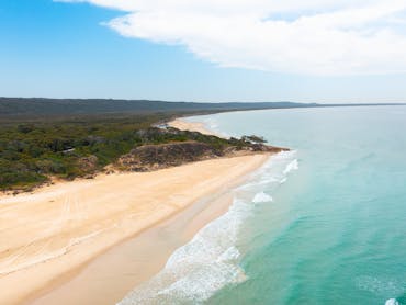 White sandy beach with turquoise waters and trees. White sandy beach with turquoise waters and trees.