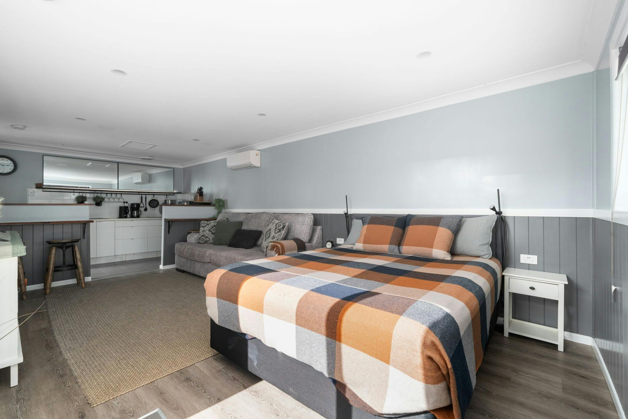 Queen bed, couch with tv and small kitchen area.