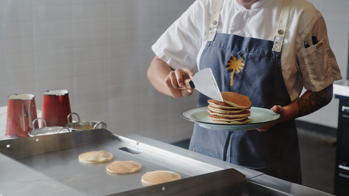 Chef cooking pancakes and serving them on a plate
